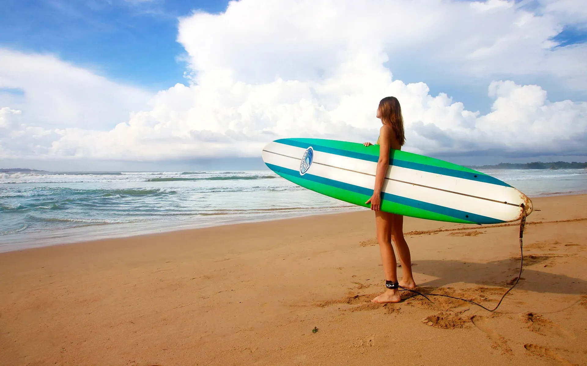 Surfer carrying a board on Weligama beach
