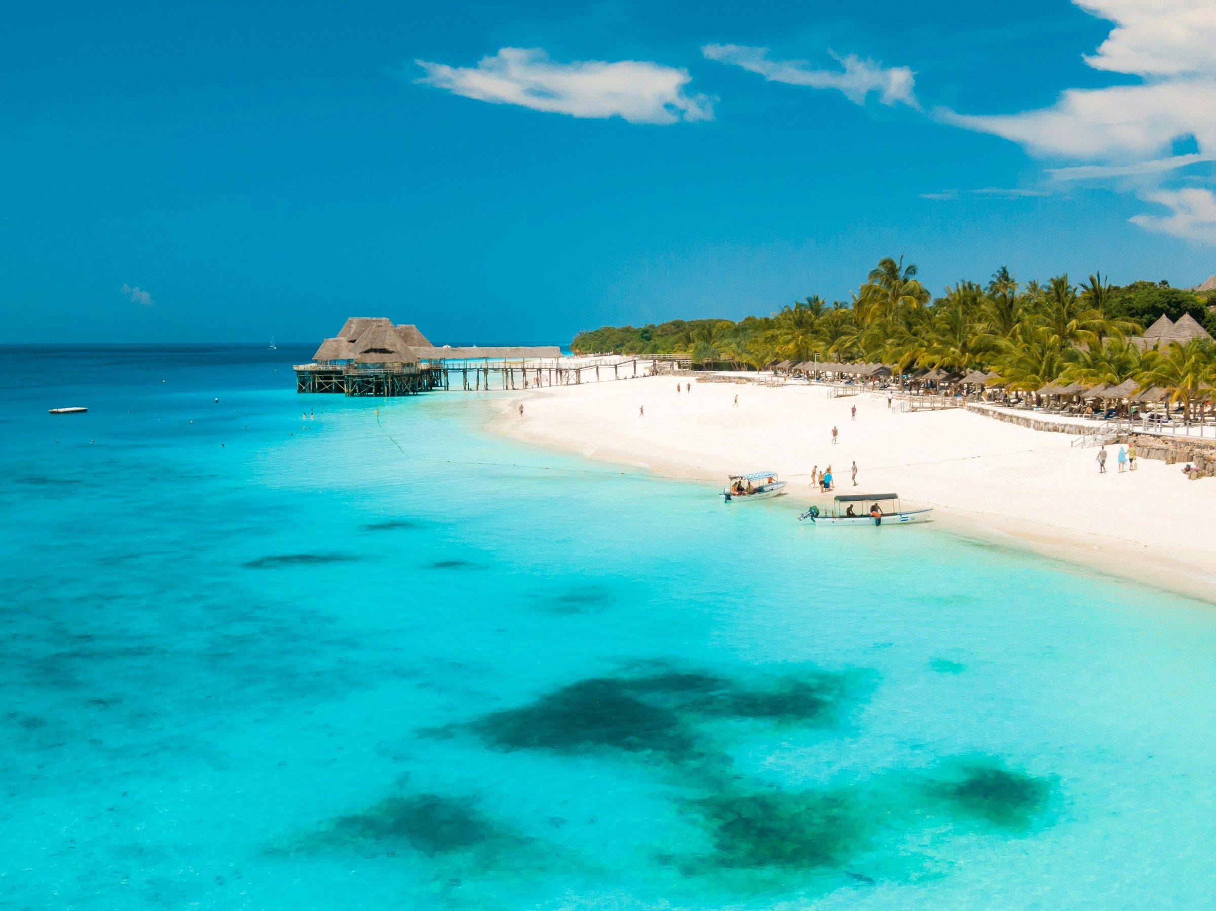 White-sand beach, jetty and boats in Zanzibar.