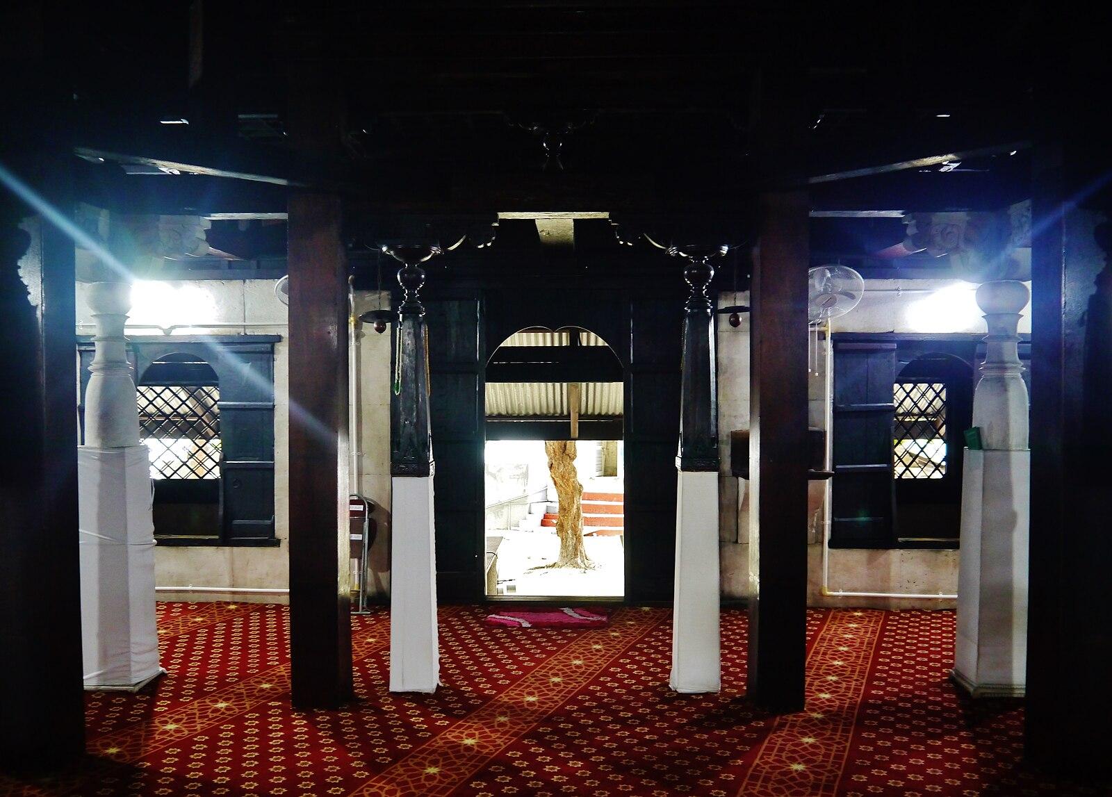 The interior of Hukuru Miskiy, Malé — carved coral stone walls and Arabic calligraphy